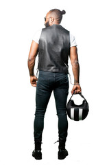 black motorcyclist full body holding a helmet