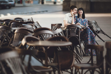 Wall Mural - Young couple is sitting on the wooden chairs