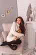 © geniuskp - beautiful young woman posing near a fireplace in a warm sweater