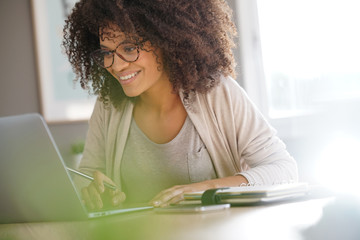 Mixed race woman working from home on laptop computer