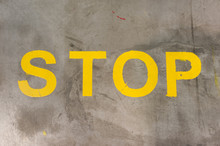 Żółty Napis STOP Namalowany Na Betonowej Podłodze