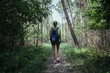 © Stasique - Active female hiker with backpack trekking through natural park in summer. Concept of camping, vacation and tourism.