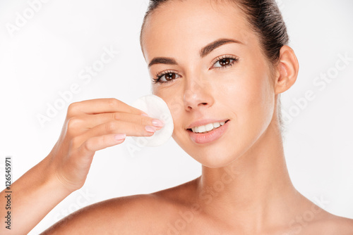 Leinwand Poster Skin care woman removing face makeup with cotton swab pad