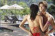 © Alexander - Couple standing face to face, man looking over shoulder of woman, rear view