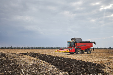 Poster - Red harvester working in a field