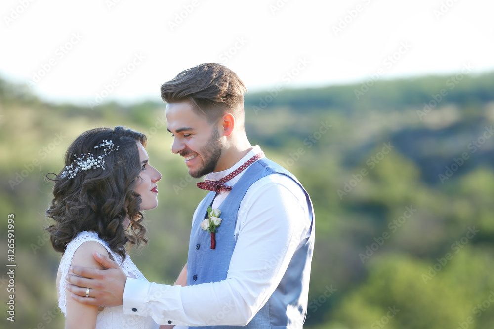 Bride and groom standing over beautiful landscape