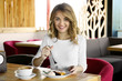 © Africa Studio - Young woman eating delicious dessert at restaurant