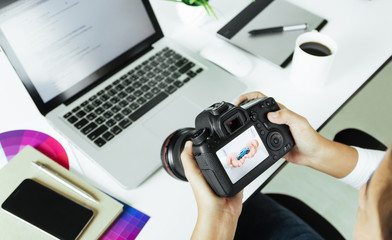 photographer checking dslr camera on desk