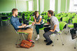 © newagecinema - people sitting in the class by the table and listening the presentation