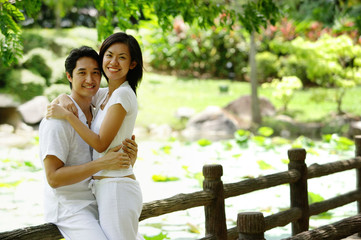 Couple embracing, smiling at camera, portrait