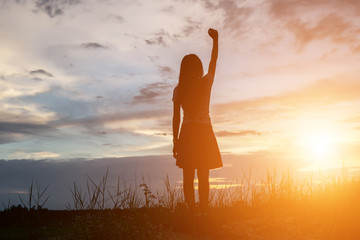 Wall Mural - Silhouette of woman praying over beautiful sky background