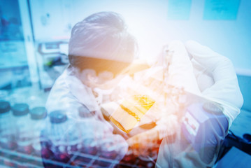 test tube in scientist hand and female scientist doing a test in laboratory.