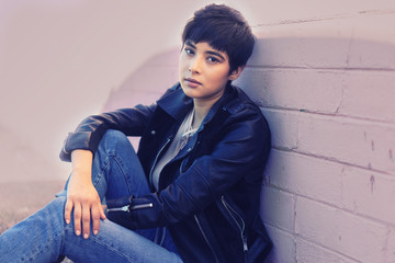 Wall Mural - Young woman with short hair sitting wearing leather jacket