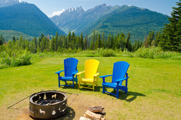 outdoor fireplace with three colorful chairs over fantastic mountain view