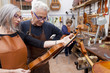 group of mature violin maker in pose while testing the violins i