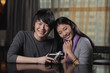 © Alexander - Young couple holding a present and smiling