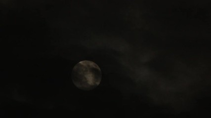 Wall Mural - time lapse of bright and beautiful full moon rising on dark and cloudy night.