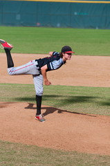 Little league baseball pitcher in wind up throwing the ball.