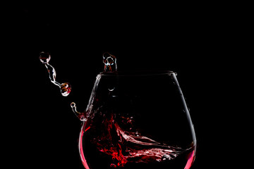 Splash of wine in the glass on dark backround