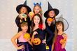 © Nichizhenova Elena - Happy group of teenagers in Halloween costumes posing on camera