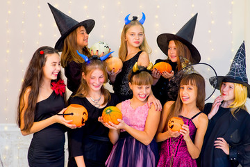 Happy group of teenagers in Halloween costumes posing on camera