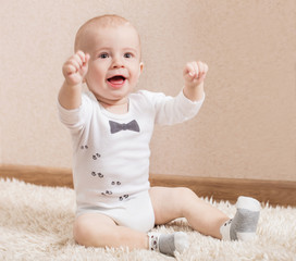 happy baby boy sitting on the floor