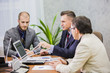 © de Art - Modern managers listening to speaker at conference or seminar, young businessman sitting in office and working with laptop