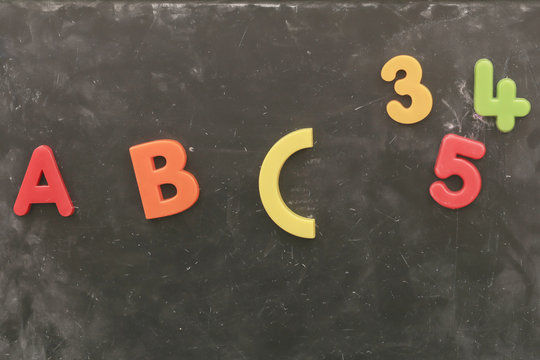 colorful plastic alphabet on chalkboard background