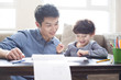 © Blue Jean Images - Young father helping son with homework