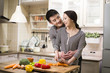 © Blue Jean Images - Young couple cooking in kitchen