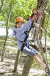 © Blue Jean Images - Happy children playing in tree top adventure park