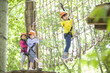 © Blue Jean Images - Happy children playing in tree top adventure park