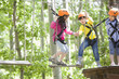 © Blue Jean Images - Happy children playing in tree top adventure park