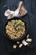 Porcini risotto in a cast-iron frying pan, top view, studio shot