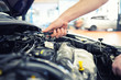 KFZ Mechaniker repariert Motor eines Fahrzeugs in der Autowerkstatt - Close Up Hand mit Werkzeug im Motorraum