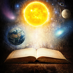 Wall Mural - opened magic book with sun, earth, moon, saturn, stars and galaxy. concept on the topic of astronomy