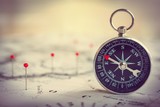Fototapeta Mapy - Magnetic compass on a world map conceptual of global travel , tourism and exploration. Macro photo.