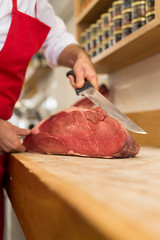 Wall Mural - Close up of butcher cutting meat