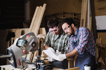 angry boss and worker together in a carpenter's workshop