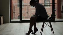 Silhouette Of A Woman In High Heels Massaging Her Tired Legs