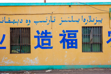 Text on the wall in Chinese and Uyghur arabic script saying 