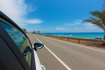 Wall Mural - white car on the road along the coast of the Mediterranean Sea w