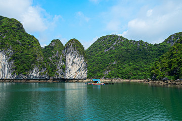 Wall Mural - Floating house and rock islands in Halong Bay, Vietnam, Southeast Asia. UNESCO World Heritage Site. Scenic landscape mountain sea at Ha Long Bay. Most popular landmark, tourist destination of Vietnam.