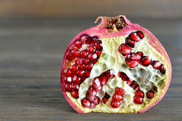 Wall Mural - Fresh pomegranate half on wooden background