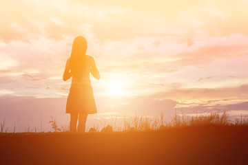 Wall Mural - Silhouette of woman praying over beautiful sky background