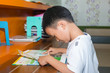 © sakdinon - Cute little boy reading book in the library