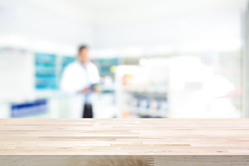 Wall Mural - Empty wood counter top on blur pharmacy  background