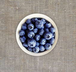 Blueberries in a white ceramic bowl. Top view. Ripe and tasty berries.