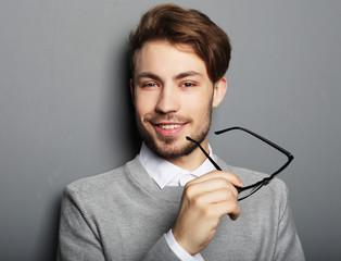 Poster -  Young  trendy man with glasses smiling, studio shot