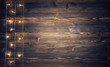 Christmas lights on rustic wooden background.